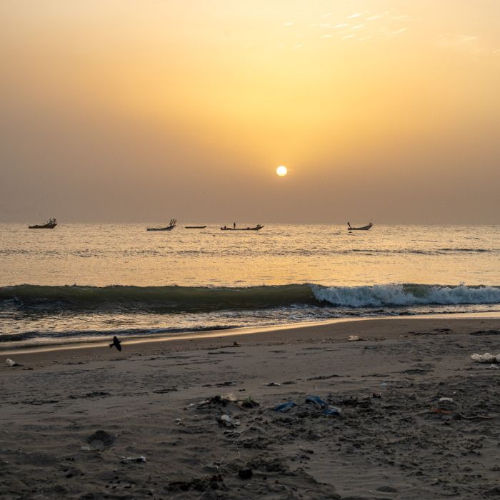 El sol se pone sobre las piraguas de pesca mientras el mar lava las orillas de la playa de Sanyang, en Gambia. Crédito de la foto: Abubacar Fofana, Febrero 22, 2024