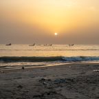 The sun sets over the wooden fishing pirogues as the sea washes the quiet beach at the Kartong, The Gambia fishing grounds. Photo credit: Abubacar Fofana