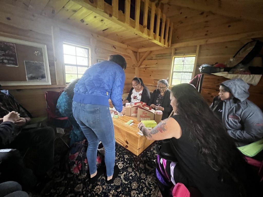 Melina Laboucan-Massimo y la familia Laboucan-Mclean se reúnen en el espacio de encuentro del Hummingbird Lodge antes de la ceremonia de su familia, en nombre de Bella. Crédito de la foto: Audrey Huntley, Fall 2023
