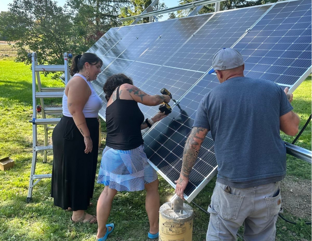 Audrey Huntley from No More Silence, Serena Mendizabal from Sacred Earth Solar, and solar installer Mike from Solar Associates installing the solar panels for the Hummingbird Lodge. Photo credit: Audrey Huntley