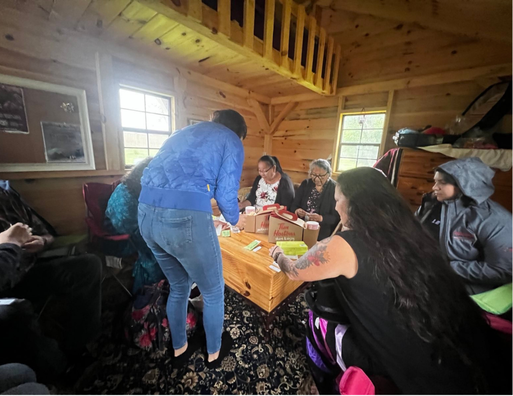 Melina Laboucan-Massimo and the Laboucan-Mclean family gather in the Hummingbird Lodge gathering space before their family's ceremony for Bella. Photo credit: Audrey Huntley