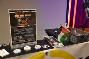 A close up view of the Crushing Colonialism table with a poster for the Hard Road of Hope prominently displayed.