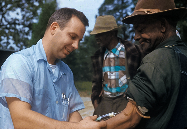 Tuskegee Syphilis Study doctor injects a Black man with a placebo.